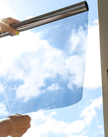 a person about to place a window film onto a window in an office