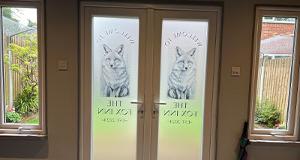 a decorative window film on double doors for an establishment called The Fox Inn