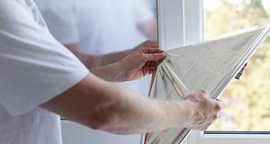 a man applying a solar control window film to a residential home